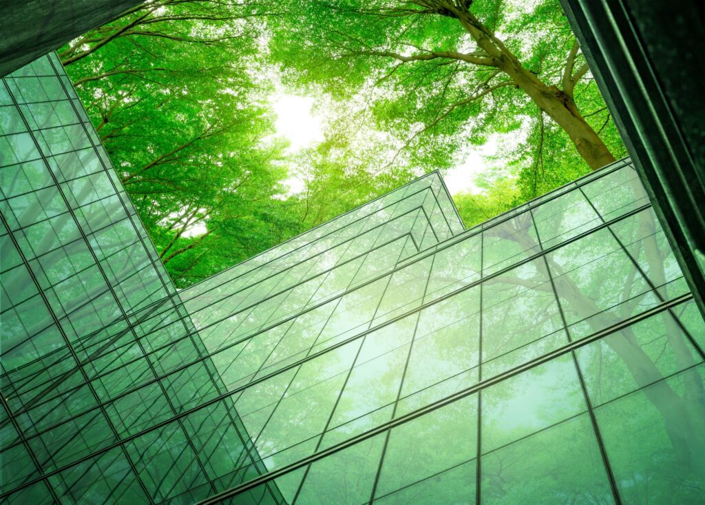 Eco-friendly building in the modern city. Sustainable glass office building with tree